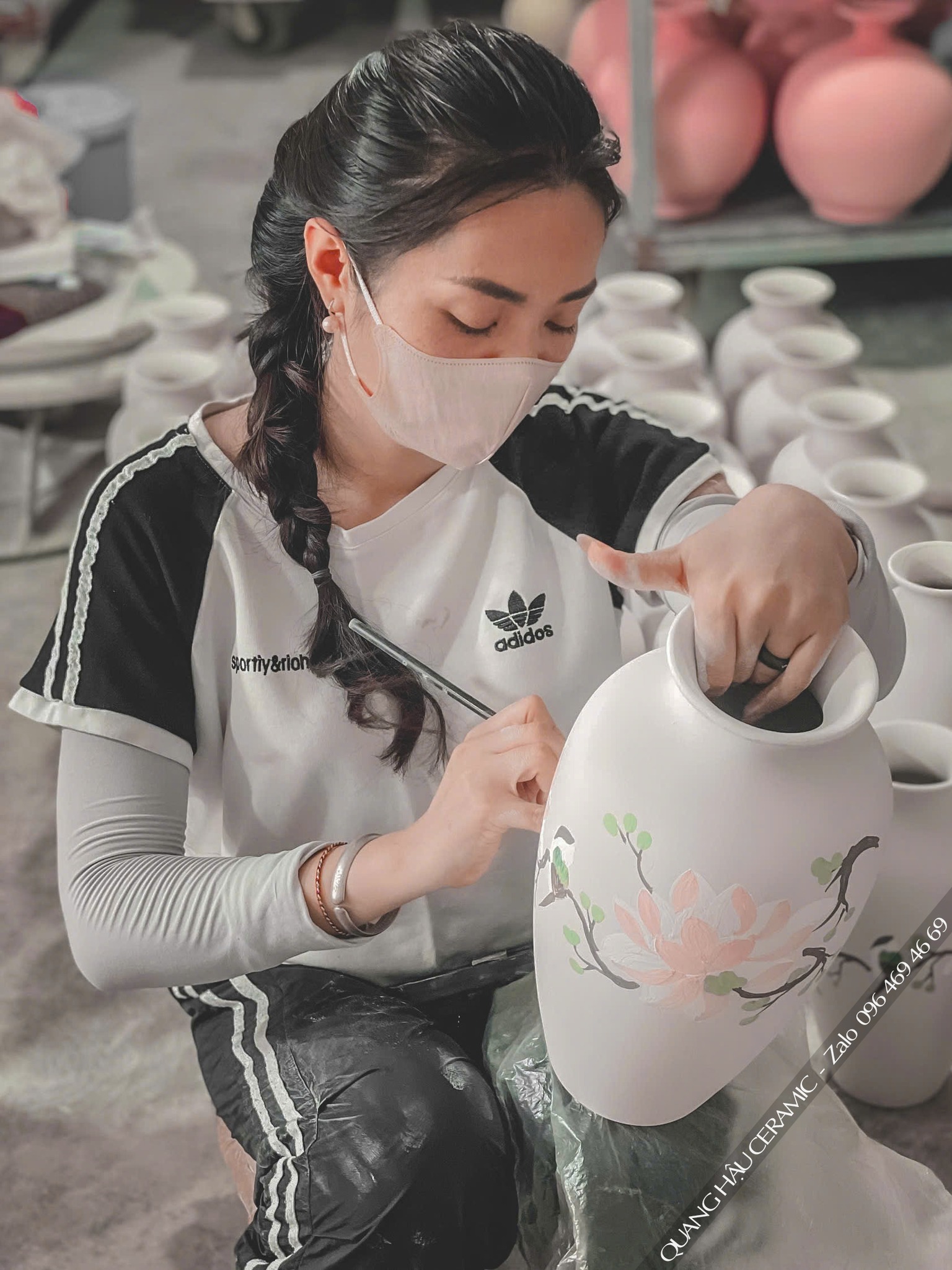 Cận cảnh nghệ nhân đang kiểm tra độ sắc nét của logo trên sản phẩm quà tặng, một bước quan trọng khi làm việc trực tiếp với xưởng sản xuất quà tặng gốm sứ.
